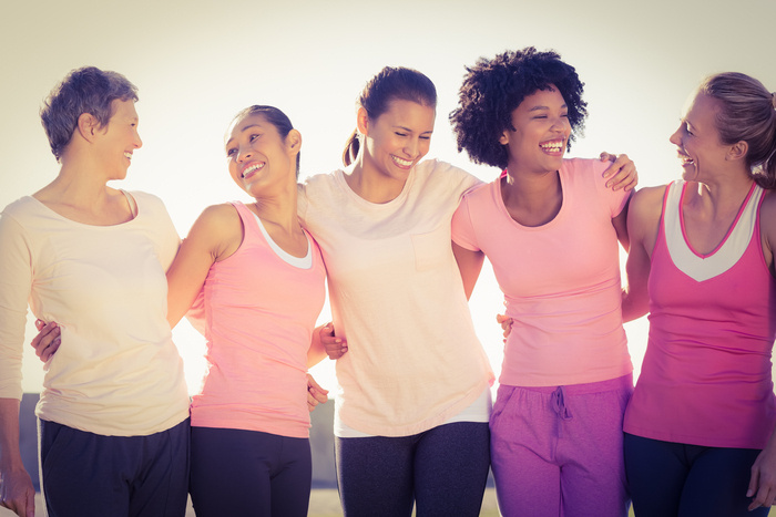 group of women with arms around each other smiling to one another