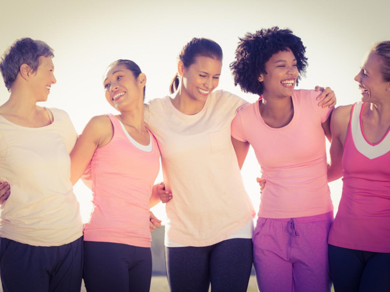 group of women with arms around each other smiling to one another